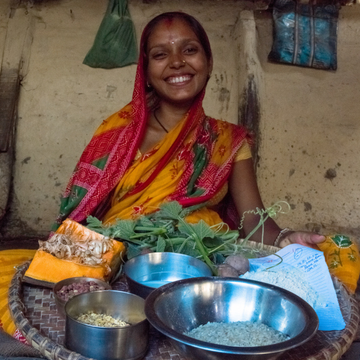 Frau lächelt und hält ein Tablet mit verschiedenen Zustten in ihrer Hand